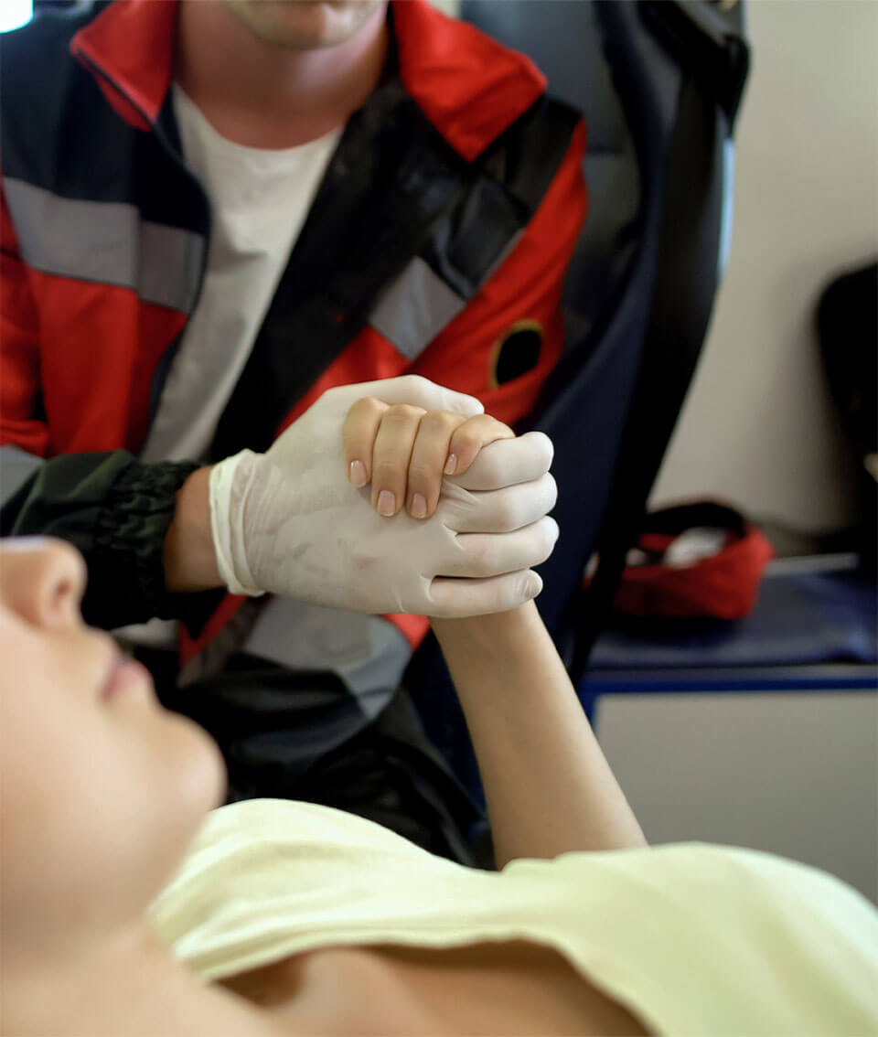 Medical staff member holding hand of woman patient.