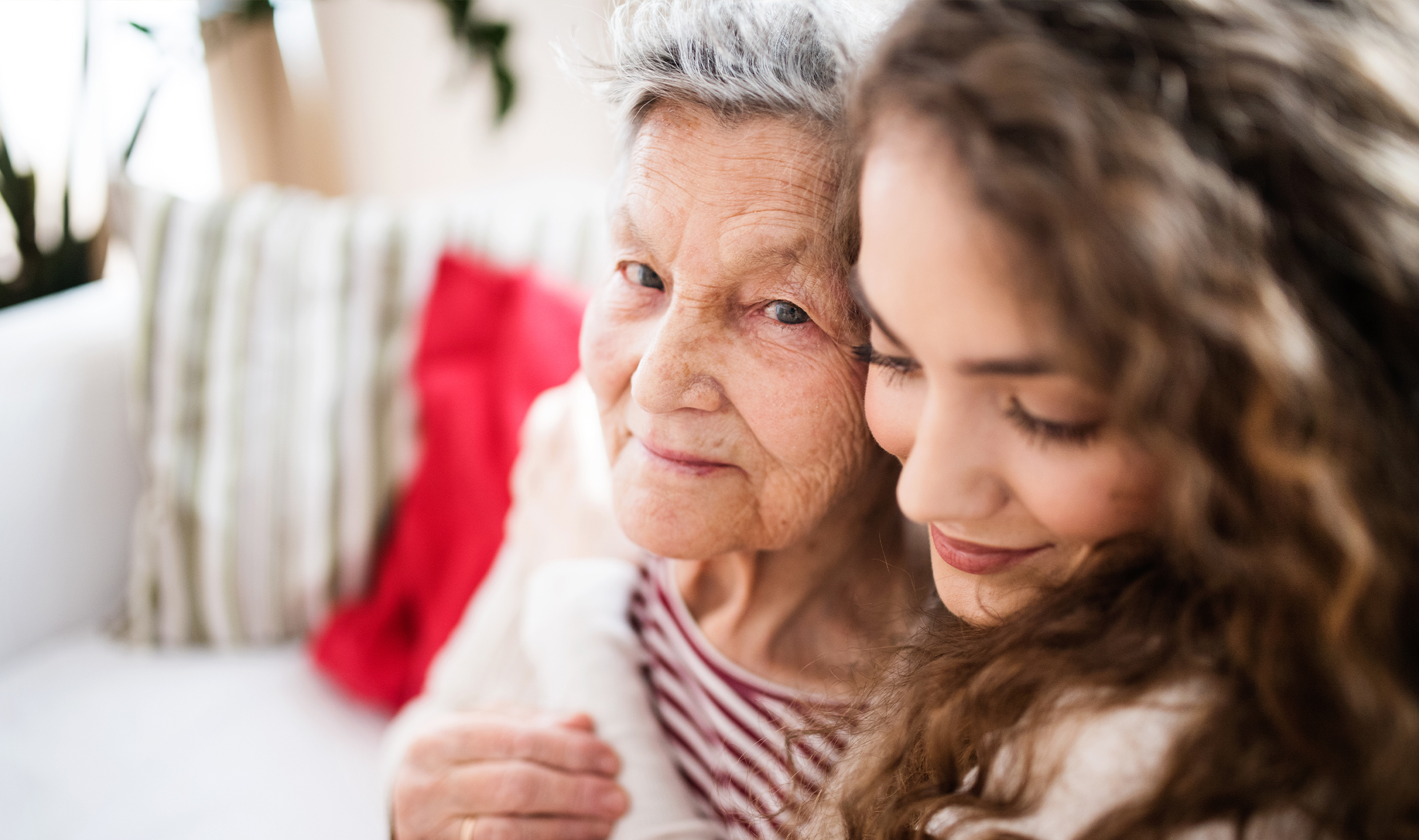 Younger woman hugging senior woman.